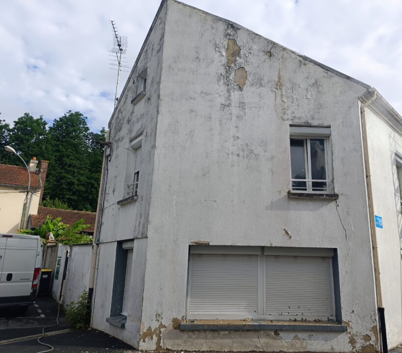 Une façade avec des fissures et des traces de salissure